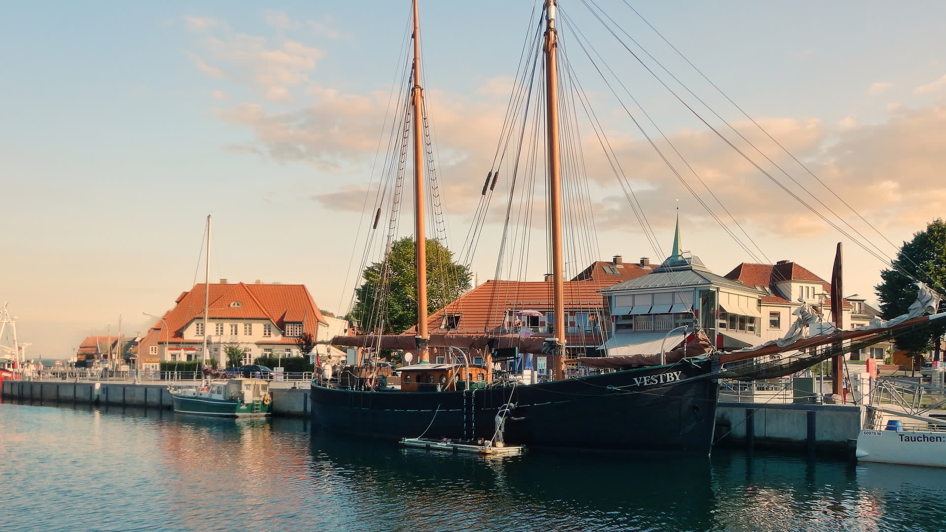 Stadthafen von Neustadt in Holstein mit einem Traditionssegler am Kai im Abendlicht
